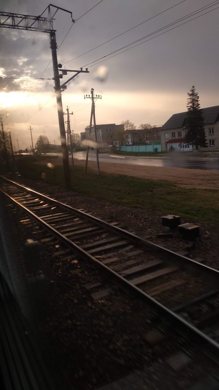 TRAIN ON RAILROAD STATION AGAINST SKY DURING SUNSET