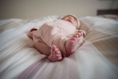 Newborn baby girl  sleeping on bed at home