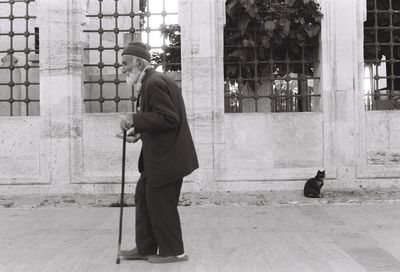 Rear view of man with umbrella in city