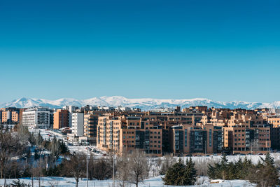 Buildings in city against clear blue sky