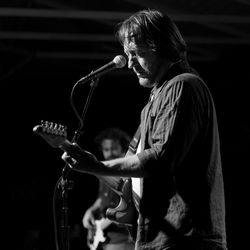 Male musician playing guitar on stage