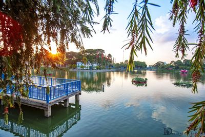 Swimming pool by lake against sky