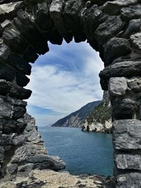 Rock formation by sea against sky