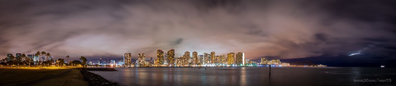 ILLUMINATED CITYSCAPE AGAINST CLOUDY SKY