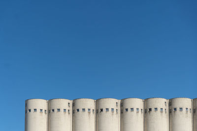 Low angle view of factory against clear blue sky