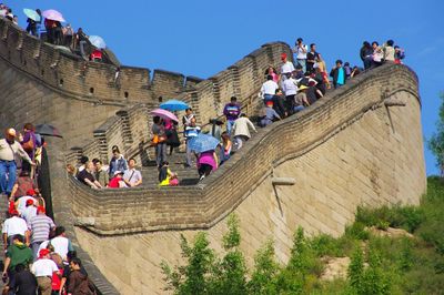 Tourists visiting great wall of china against clear blue sky