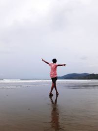 Full length of man standing on beach against sky