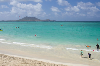 People on beach against sky