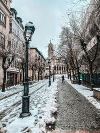Street amidst buildings in city during winter