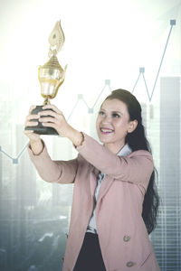 Businesswoman holding trophy