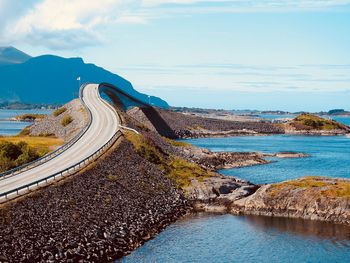 Scenic view of sea by road against sky