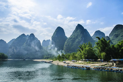 Scenic view of river and mountains against sky