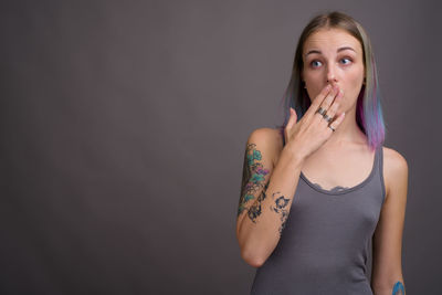 Portrait of woman standing against wall