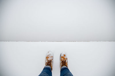 Low section of person standing on white wall