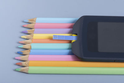 High angle view of colored pencils on blue background