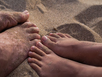 Low section of man and woman on sand