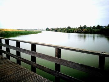 Pier over lake against clear sky