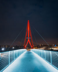 Illuminated suspension bridge against sky at night