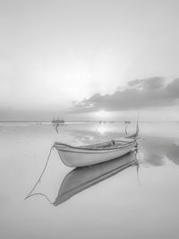 Boat moored in sea against sky