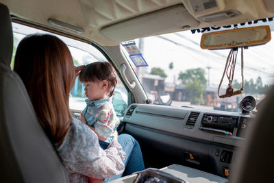 Mother and daughter sitting in car