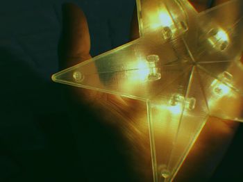 Close-up of illuminated lighting equipment against black background