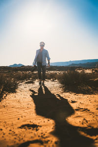Full length of man standing on beach against sky
