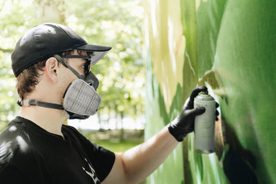 Man spraying paint on wall