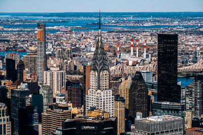 High angle view of modern buildings by sea against sky