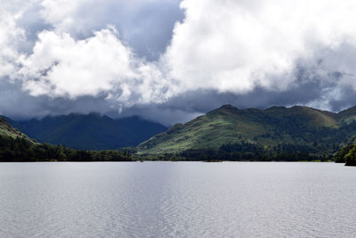 Scenic view of lake by mountains against sky