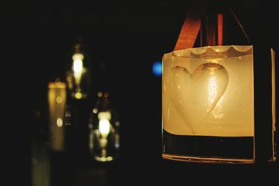 Close-up of illuminated candle against black background