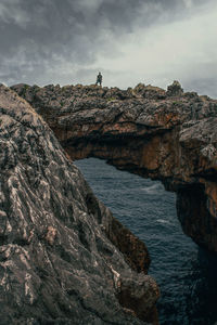 Scenic view of sea by rock formation against sky