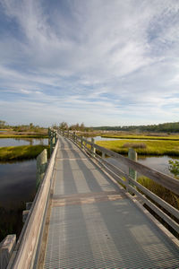 Empty pathway bridge over coastal landscape