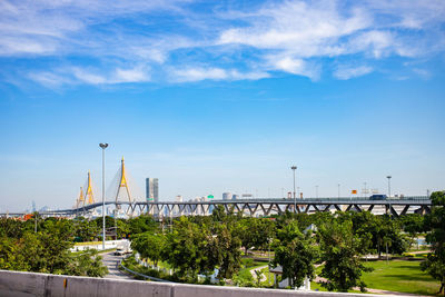 Road by bridge against sky in city