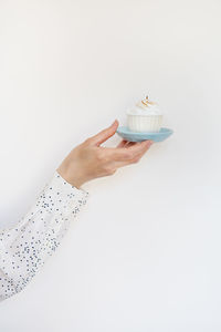 A female hand holds a delicious cupcake, congratulations on a happy birthday