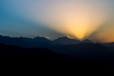 Scenic view of silhouette mountains against sky during sunset