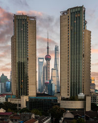 Modern buildings in city against cloudy sky in shanghai