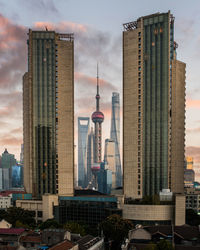 Modern buildings in city against cloudy sky