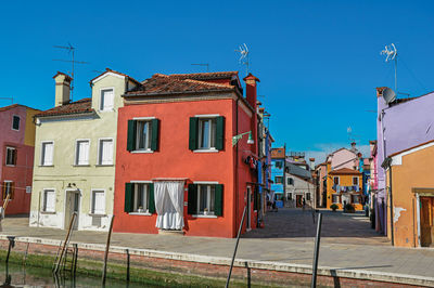 Colorful buildings in a sunny day at burano, a little town full of canals near venice, italy.