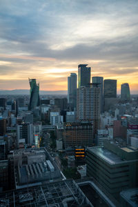 High angle view of modern buildings in city against sky during sunset