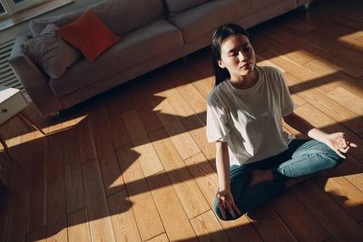 High angle view of woman sitting on floor at home