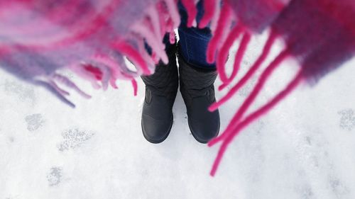 Low section of woman standing on snow covered field