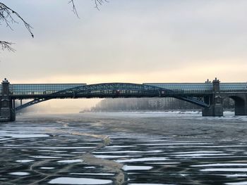 Bridge over river against sky during sunset