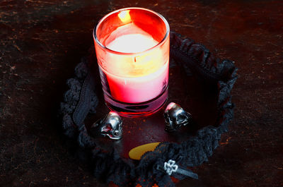 High angle view of tea light candle and garter on table