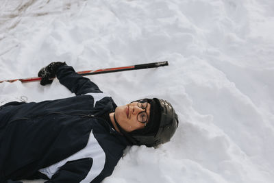 Smiling man lying on snow