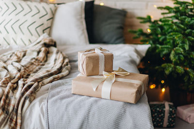 Beautifully wrapped christmas presents in a decorated bedroom with christmas tree on background