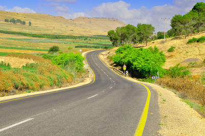 Road passing through landscape against sky