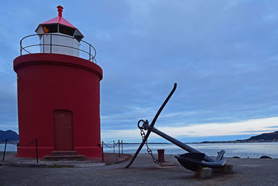 Lighthouse by sea against sky