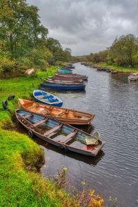 Boat moored on lake against sky