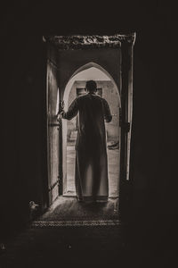 Rear view of  man standing against door