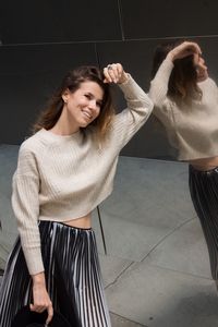 Young woman standing against wall